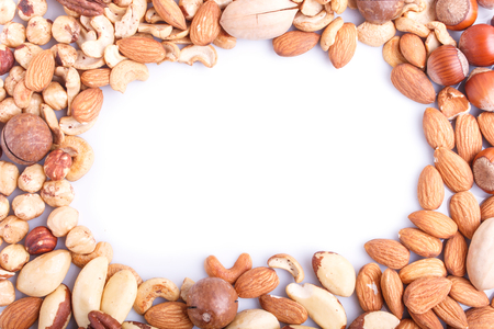Frame made from different kinds of nuts on white background. hazelnut, brazil nut, almond, pumpkin seeds, cashew.  top view.の写真素材