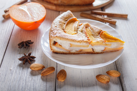 A slice of sweet persimmon pie on white wooden background. close up.の写真素材