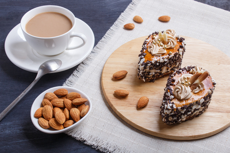 Cakes with chocolate chips  and cream decorations  on wooden board on black woodenの写真素材