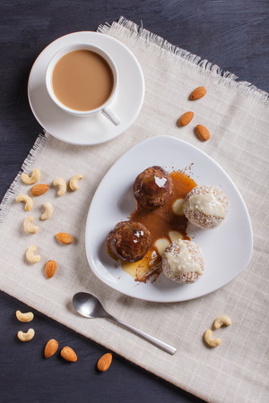 Energy balls cakes with chocolate  caramel and coconut on white plate on linen napkin, top view.の写真素材