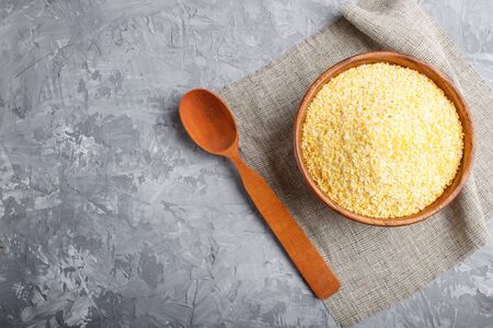 wooden bowl with cornflakes and a wooden spoon on a gray concrete background.  linen napkin, top view, copy space.の写真素材