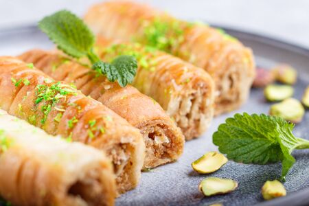 Baklava, traditional arabic sweets in gray ceramic plate on a gray concrete background. side view, close up, selective focus.の写真素材