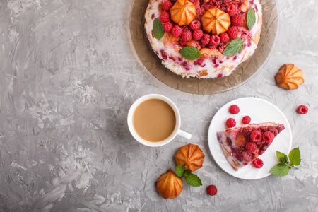 Homemade jelly cake with milk, cookies and raspberry on a gray concrete  background with cup of coffee. top view. flat lay, copy space.の写真素材