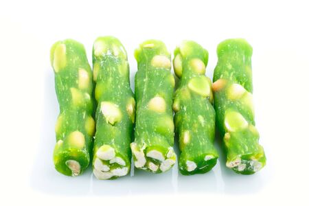 green traditional turkish delight (rahat lokum) with peanuts isolated on white background. side view, close up.の写真素材