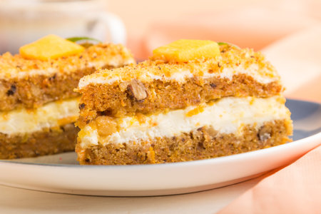 Homemade cake with persimmon and pumpkin and a cup of coffee on a white wooden background with orange textile. side view, close up, selective focus.の写真素材
