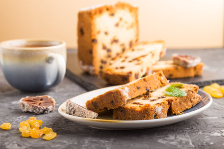 Homemade cake with raisins, dried persimmon and a cup of hot chocolate on a black concrete...