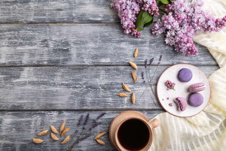 Purple macarons or macaroons cakes with cup of coffee on a gray wooden background and white linen textile. Top view, flat lay, copy space.の写真素材