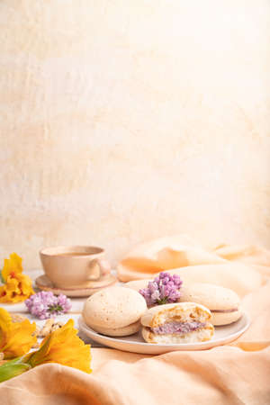 Meringues cakes with cup of coffee on a white background and orange linen textile. Side view, copy space, selective focus.の写真素材