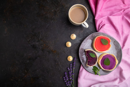 Sweet tartlets with jelly and milk cream with cup of coffee on a black concrete background and pink...