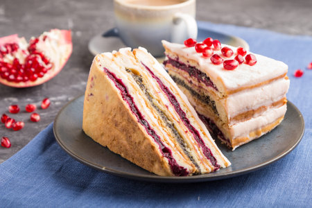 Homemade layered cake with pomegranate jam and a cup of coffee on a black concrete background and...