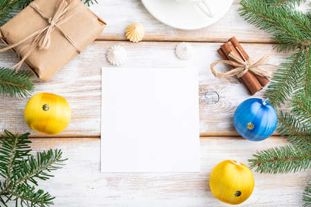 Christmas or New Year frame composition, template. Decorations, box, balls, cinnamon, ribbons, fir and spruce branches, cup of coffee, on a white wooden background. Top view, copy space, flat lay.の写真素材