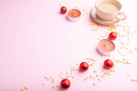 Christmas or New Year composition. Decorations, red balls, cup of coffee, on a pink paper background. Side view, copy space.の写真素材