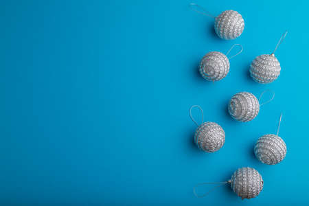 Christmas or New Year composition. Decorations, silver balls, on a blue paper background. Top view, copy space, flat lay.の写真素材