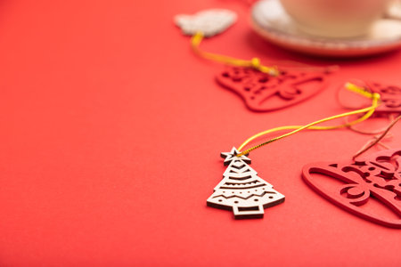 Christmas or New Year composition. Decorations, fir and spruce branches, cup of coffee, on a red paper background. Side view, selective focus, copy space.の写真素材