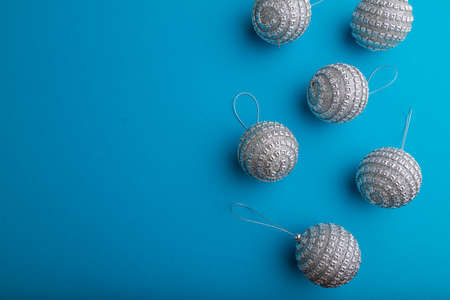 Christmas or New Year composition. Decorations, silver balls, on a blue paper background. Top view, copy space, flat lay.の写真素材