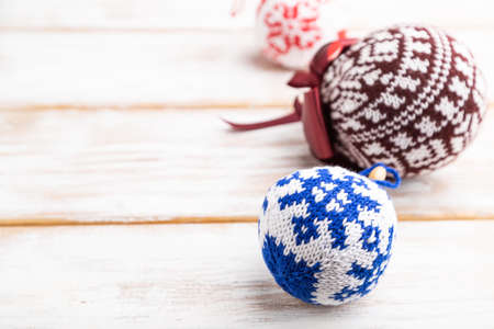 Christmas or New Year composition. Decorations, knitted balls, on a white wooden background. Side view, copy space, selective focus.の写真素材