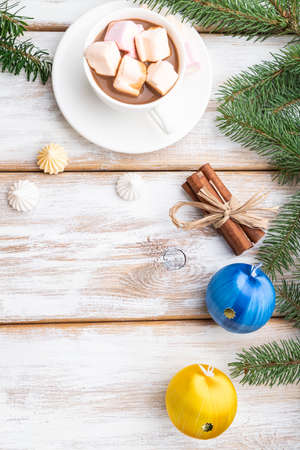 Christmas or New Year frame composition. Decorations, box, balls, cinnamon, ribbons, fir and spruce branches, cup of coffee, on a white wooden background. Top view, copy space, flat lay.の写真素材