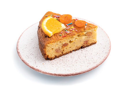 Piece of orange cake on ceramic plate isolated on a white background. Side view, close upの写真素材