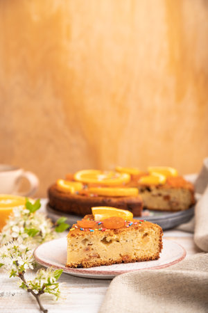Orange cake and a cup of coffee on a white wooden background and linen textile. Side view, copy space, selective focus.の写真素材