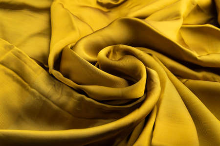 Fragment of yellow and green tissue. Side view, synthetic textile background and texture. wave concept, abstract.の写真素材