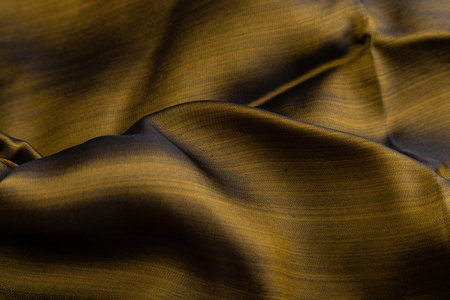 Fragment of yellow and green tissue. Side view, synthetic textile background and texture. wave concept, abstract.の写真素材