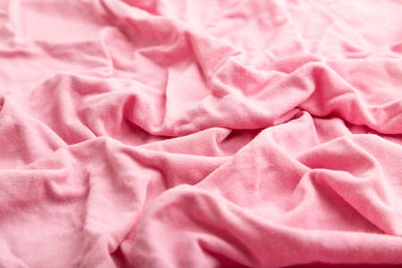 Fragment of pink cotton tissue. Side view, natural textile background and texture. wave concept, abstract.の写真素材