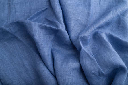 Fragment of blue linen tissue. Top view, natural textile background and texture. wave concept, abstract.の写真素材