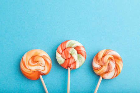 Three lollipop candies on blue pastel background. copy space, top view, flat lay.の写真素材