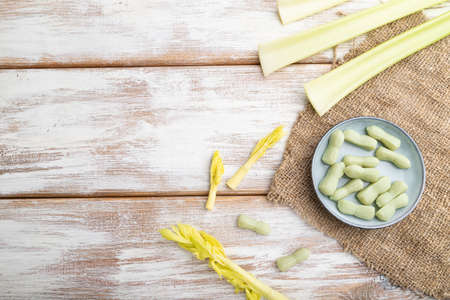 Jelly celery candies on white wooden background and linen textile. copy space, top view, flat lay.の写真素材