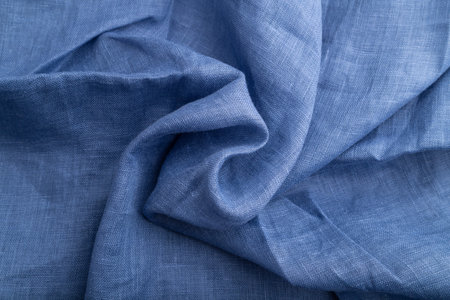 Fragment of blue linen tissue. Top view, natural textile background and texture. wave concept,...