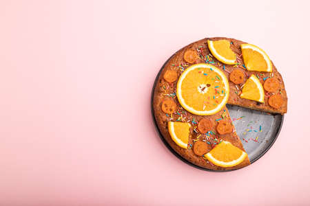 Orange cake on a pastel pink background. Top view, flat lay, copy space.の写真素材