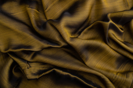 Fragment of yellow and green tissue. Side view, synthetic textile background and texture. wave concept, abstract.の写真素材
