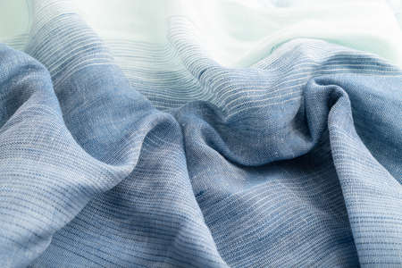 Fragment of blue linen tissue. Side view, natural textile background and texture. wave concept, abstract.の写真素材
