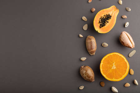 Ripe cut papaya, orange, seashells on gray pastel background. Top view, flat lay, copy space. Tropical, healthy food, vacation, holidays concept, minimalism.の写真素材