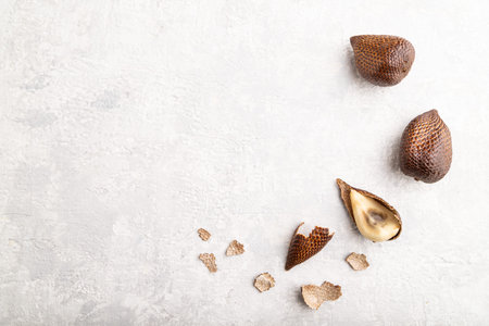 Salak or snake fruit on gray concrete background. Top view, flat lay, copy space. Tropical, healthy...