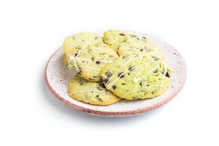 Green cookies with chocolate and mint on ceramic plate isolated on white background. side view, close up.の写真素材