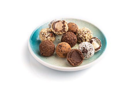 Chocolate truffle candies isolated on white background. side view, close up.