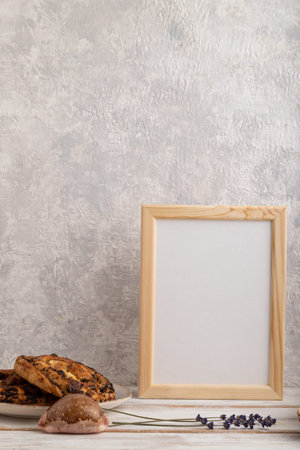 White wooden frame mockup with lavender in ceramic vase, linen textile, cup of coffee and bun on...