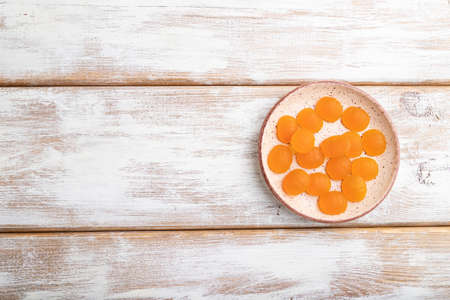 Jelly pumpkin candies on white wooden background. copy space, top view, flat lay.の写真素材