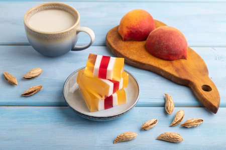 Almond milk and peach jelly on blue wooden background. side view, close up.の写真素材