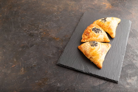 Homemade asian pastry samosa on black concrete background. side view, copy space.の写真素材