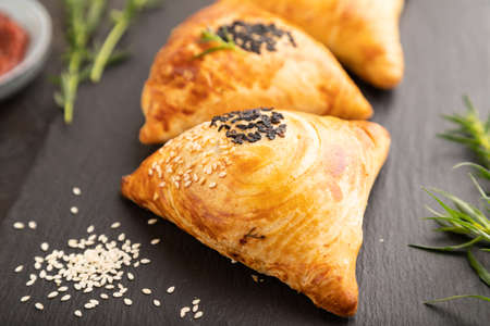 Homemade asian pastry samosa on black concrete background. side view, selective focus.の写真素材