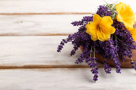 Beautiful day lily and lavender flowers on white wooden background, side view, copy space.の写真素材