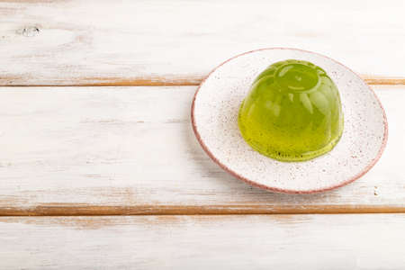 Mint green jelly on white wooden background. side view, copy space.の写真素材