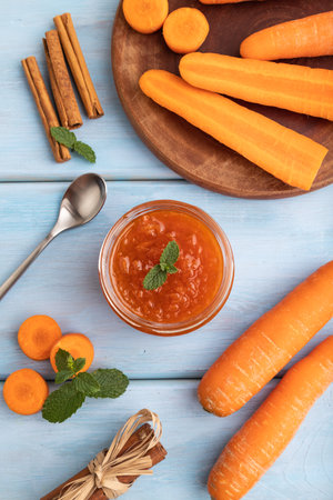Carrot jam with cinnamon in glass jar on blue wooden background. Top view, flat lay, close up.の写真素材