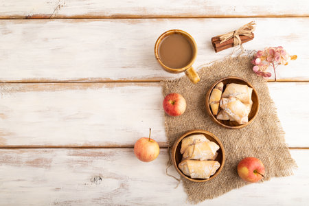 Homemade sweet cookie with apple jam and cup of coffee on white wooden background and linen textile. top view, flat lay, copy space.の写真素材