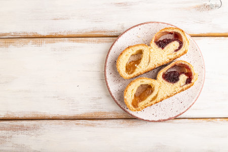 Homemade sweet bun with apricot jam on white wooden background. top view, flat lay, copy space.の写真素材
