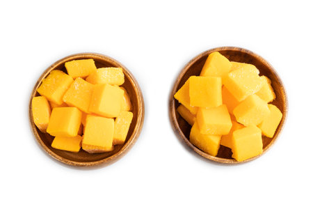 Dried and candied mango cubes in wooden bowls isolated on white background. Top view, flat lay, close up, vegan, vegetarian food concept.の写真素材