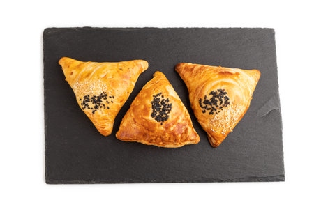 Homemade asian pastry samosa on black slate board isolated on white background. top view, flat lay, close up.の写真素材