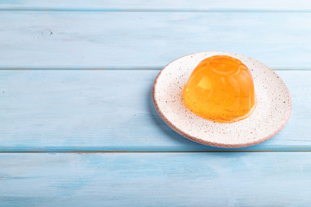 Apricot orange jelly on blue wooden background. side view, copy space.の写真素材